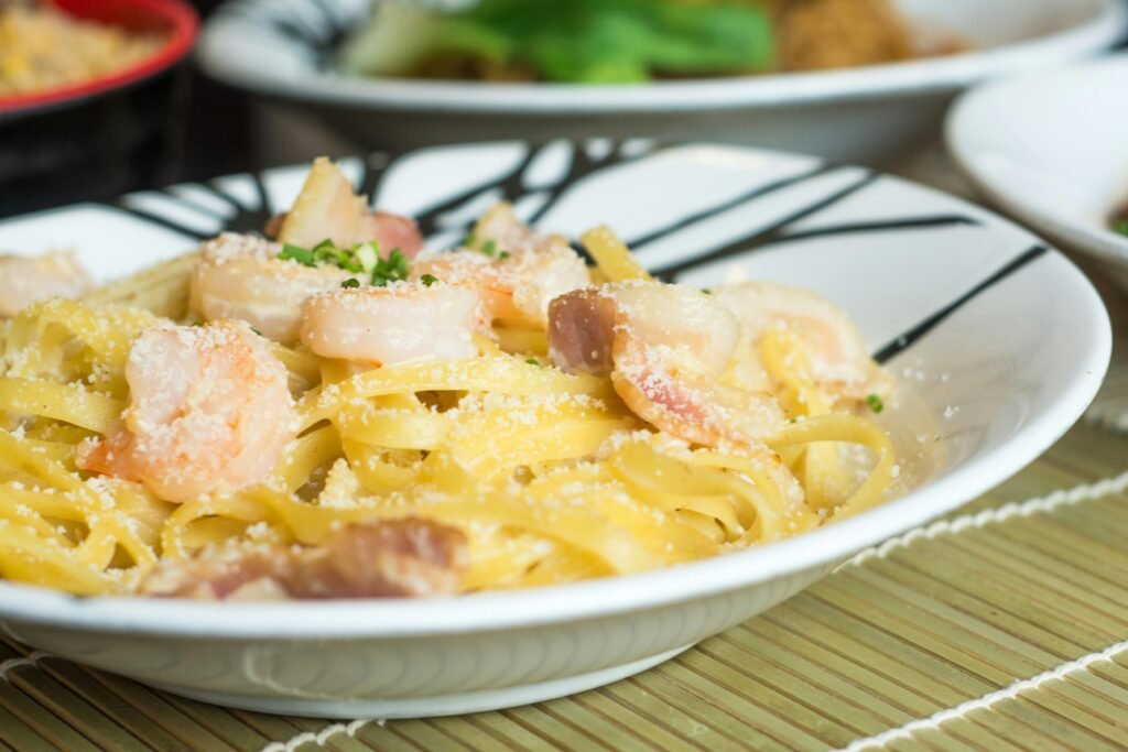 Garlic butter shrimp pasta in a pan with parsley garnish