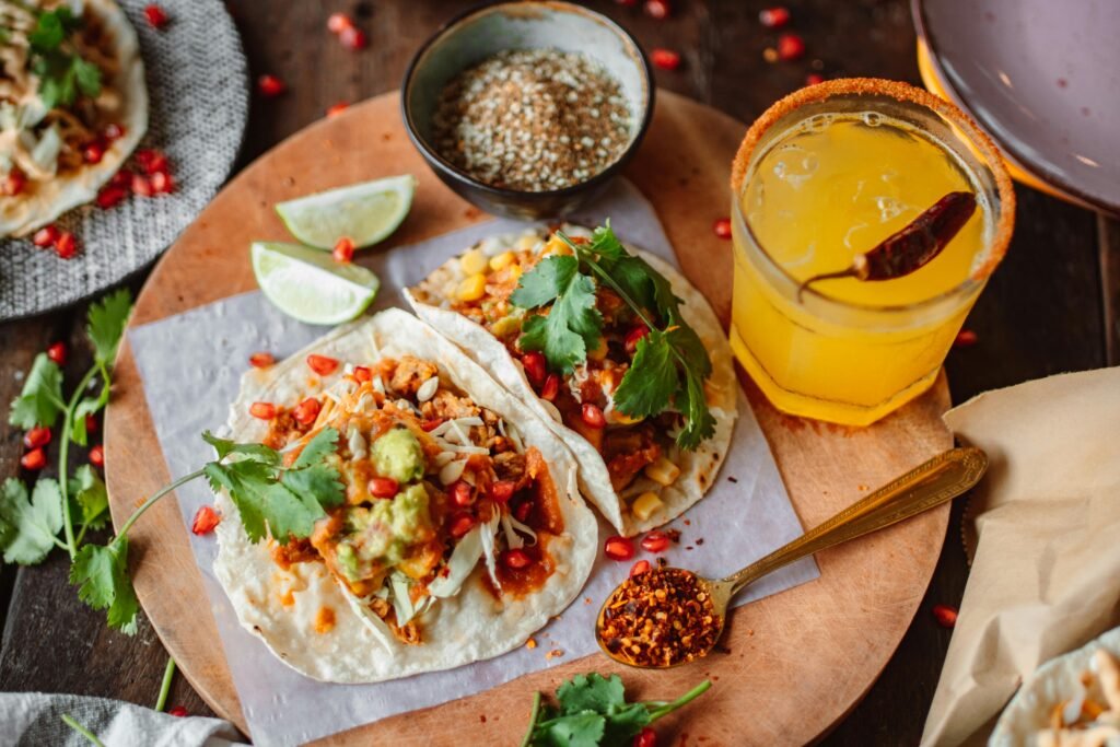 Chicken tacos with lettuce, salsa, and cheese on a wooden board